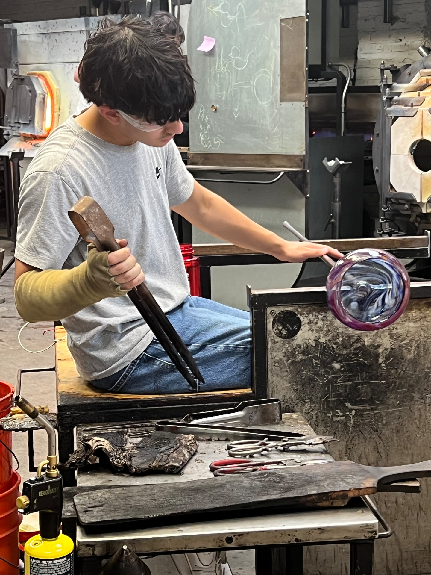 Nikhil A. Saha shaping glass in the studio